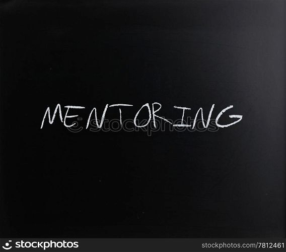 "The word "Mentoring" handwritten with white chalk on a blackboard."
