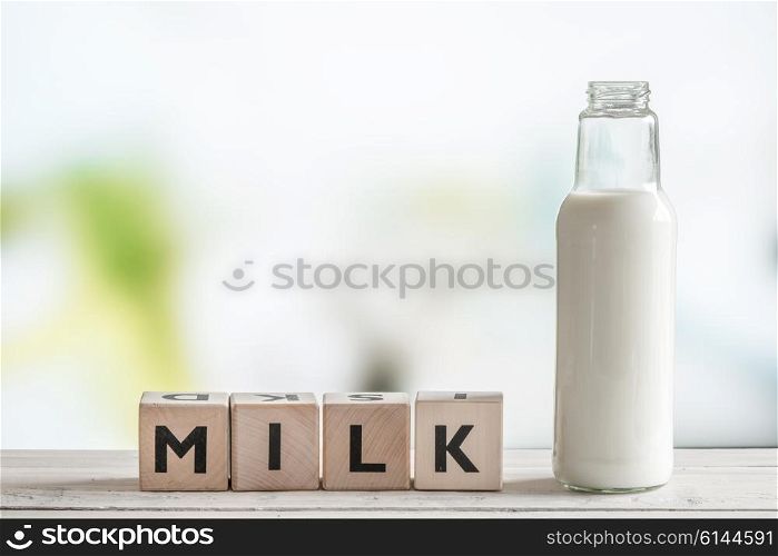 The word milk and a bottle on a wooden table