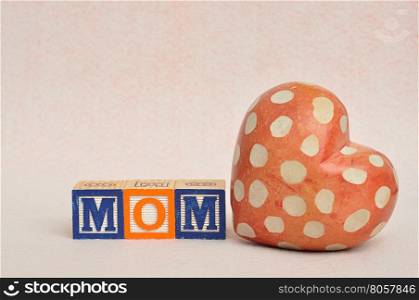 The word mom spelled with alphabet blocks with a heart