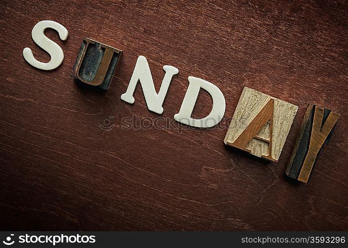 The word sunday written on wooden background
