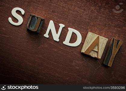 The word sunday written on wooden background