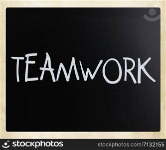 "The word "Teamwork" handwritten with white chalk on a blackboard"