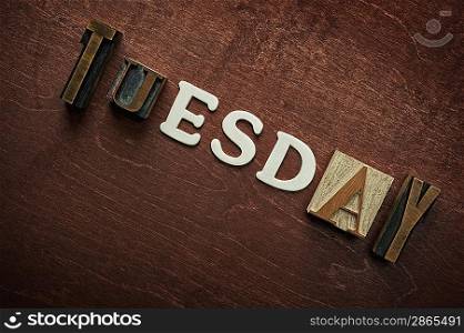 The word tuesday written on wooden background