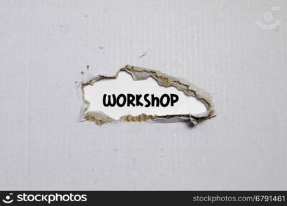 The word workshop appearing behind torn paper