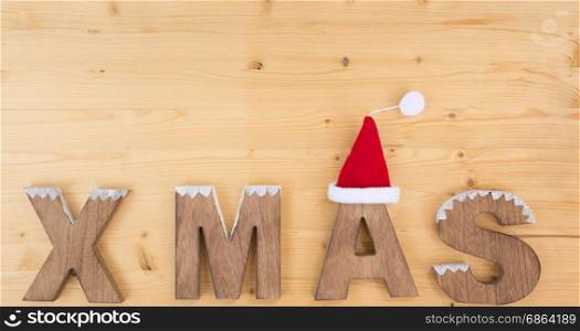 The word X MAS made on wood on wood and santa claus hat