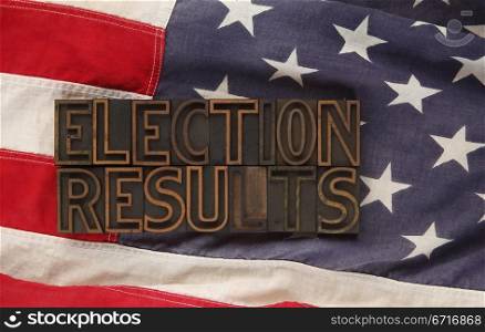 the words election results in old wood type on an American flag