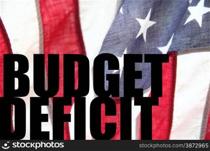 the words &rsquo;budget deficit&rsquo; on an American flag background