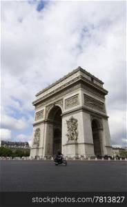 The World Famous Arc de Triomphe on the Champs ?lisZe in paris with a three point perspective and a motor cyclist in front in slight motion blur.