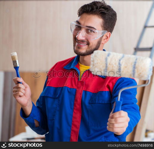 The yooung repairman carpenter working with paint painting. Yooung repairman carpenter working with paint painting