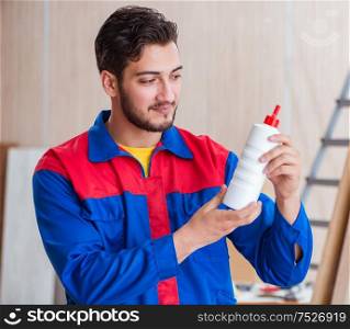 The yooung repairman carpenter working with paint painting. Yooung repairman carpenter working with paint painting