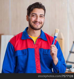 The yooung repairman carpenter working with paint painting. Yooung repairman carpenter working with paint painting