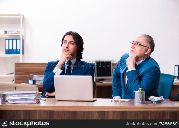 The young and old employees working together in the office. Young and old employees working together in the office