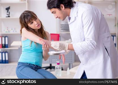 The young arm injured woman visiting young doctor traumatologist. Young arm injured woman visiting young doctor traumatologist