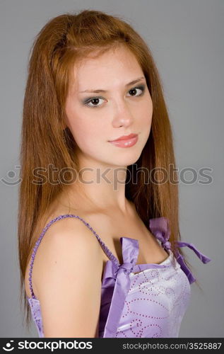 The young attractive girl in a magenta ball dress