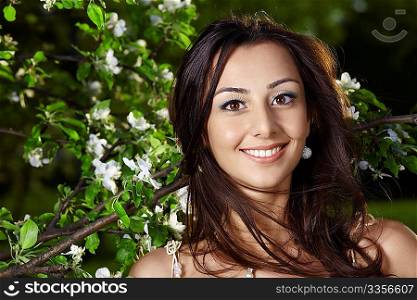 The young attractive girl in blossoming trees