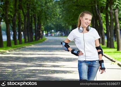 The young attractive girl with ear-phones in park