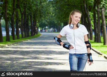 The young attractive girl with ear-phones in park
