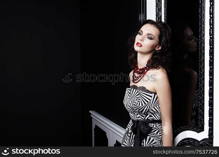 The young beautiful girl at a black-and-white door