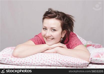 The young beautiful girl lying in bed and cheerful smiles