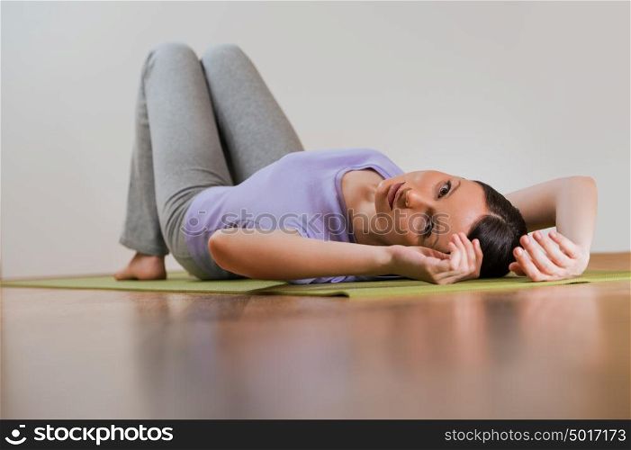 The young beautiful girl relaxing during doing exercises at home or gym