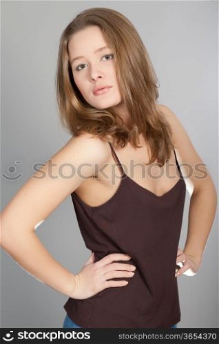 The young beautiful girl with long hair on a grey background