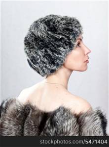 The young beautiful woman in a fur hat