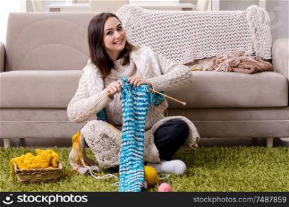 The young beautiful woman knitting at home . Young beautiful woman knitting at home