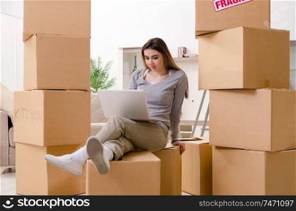 The young beautiful woman moving to new flat . Young beautiful woman moving to new flat 