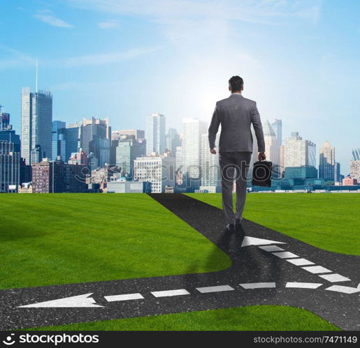 The young businessman at crossroads in uncertainty concept. Young businessman at crossroads in uncertainty concept