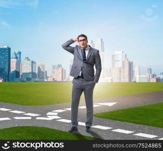 The young businessman at crossroads in uncertainty concept. Young businessman at crossroads in uncertainty concept