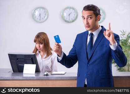 The young businessman at hotel reception. Young businessman at hotel reception