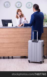 The young businessman at hotel reception. Young businessman at hotel reception