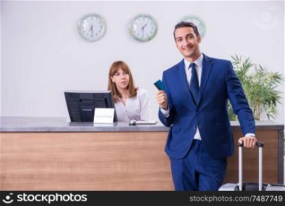 The young businessman at hotel reception. Young businessman at hotel reception