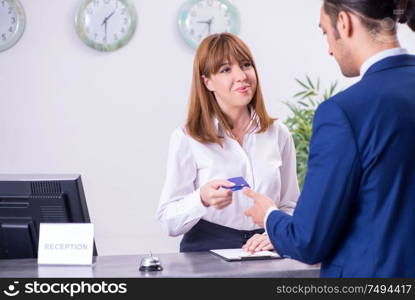 The young businessman at hotel reception. Young businessman at hotel reception