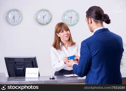 The young businessman at hotel reception. Young businessman at hotel reception