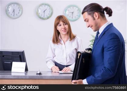 The young businessman at hotel reception. Young businessman at hotel reception