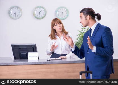 The young businessman at hotel reception. Young businessman at hotel reception