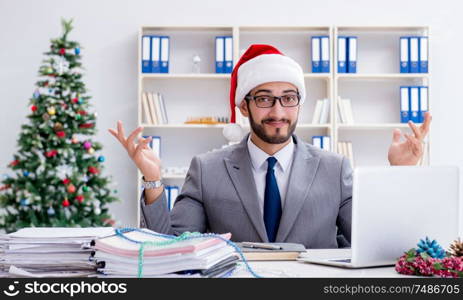 The young businessman celebrating christmas in the office. Young businessman celebrating christmas in the office