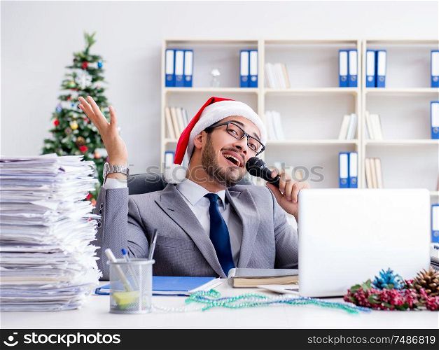 The young businessman celebrating christmas in the office. Young businessman celebrating christmas in the office