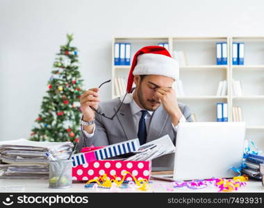 The young businessman celebrating christmas in the office. Young businessman celebrating christmas in the office