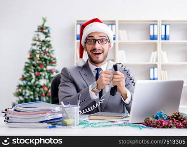 The young businessman celebrating christmas in the office. Young businessman celebrating christmas in the office