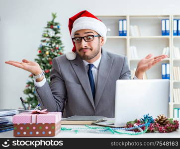 The young businessman celebrating christmas in the office. Young businessman celebrating christmas in the office