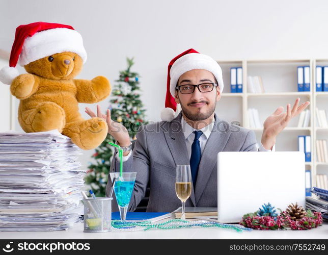 The young businessman celebrating christmas in the office. Young businessman celebrating christmas in the office