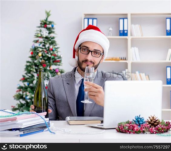The young businessman celebrating christmas in the office. Young businessman celebrating christmas in the office