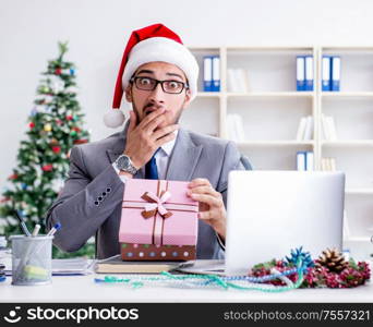 The young businessman celebrating christmas in the office. Young businessman celebrating christmas in the office