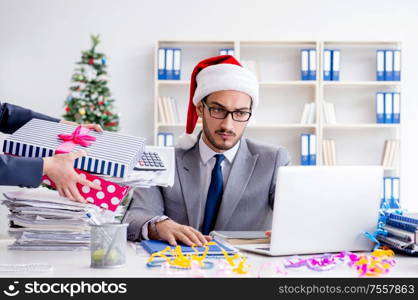 The young businessman celebrating christmas in the office. Young businessman celebrating christmas in the office