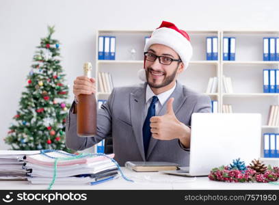 The young businessman celebrating christmas in the office. Young businessman celebrating christmas in the office