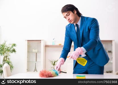 The young businessman cleaning the house. Young businessman cleaning the house