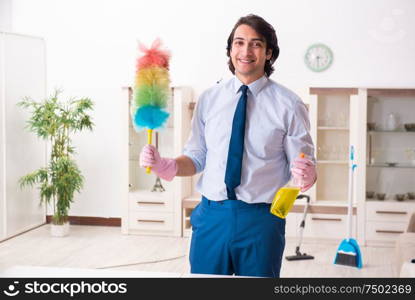 The young businessman cleaning the house. Young businessman cleaning the house