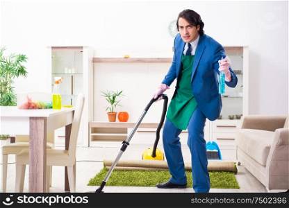 The young businessman cleaning the house. Young businessman cleaning the house